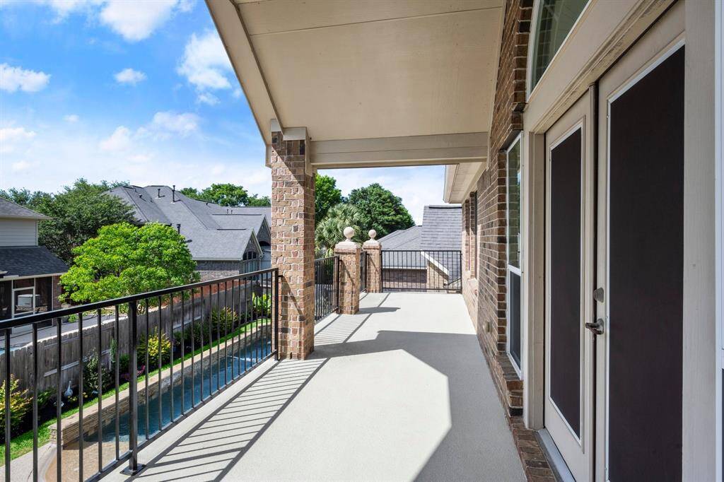 Balcony on the back of the house overlooking the pool and backyard.