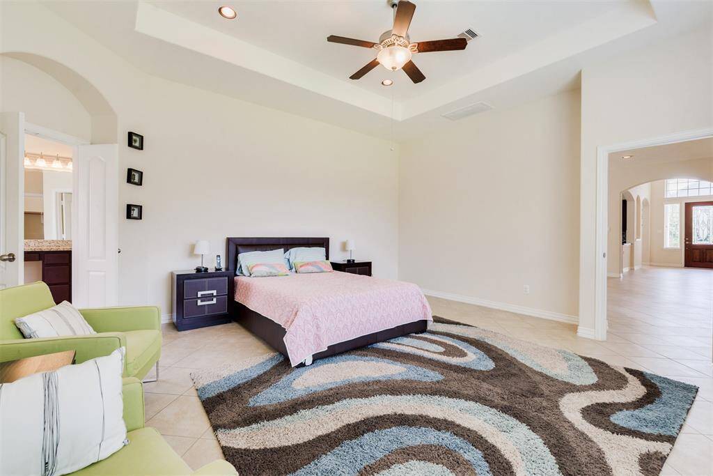 Master bedroom features tall ceilings and double doors, giving access to the spacious bath.