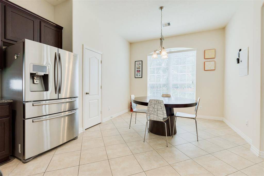 Beautiful stainless steel double door refrigerator! This huge kitchen has enough space for a breakfast table.