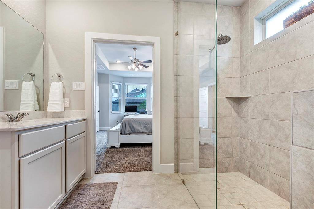 Enjoy the convenience of an en-suite bathroom in the main bedroom, featuring a sleek, glass-enclosed modern shower.