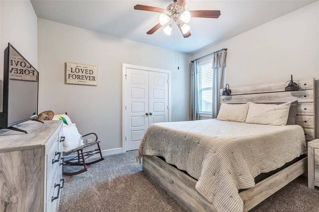 Cozy and comfortable, this bedroom features a ceiling fan for added comfort and a soft carpeted floor.