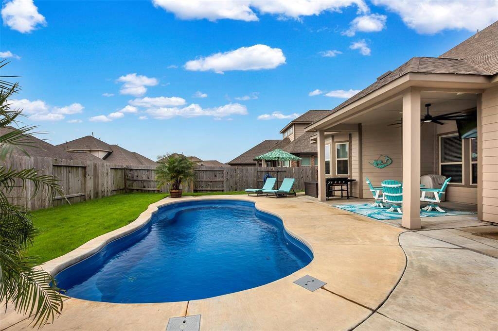 The backyard features a covered patio and a sparkling swimming pool, offering the perfect setting for relaxation and entertaining.