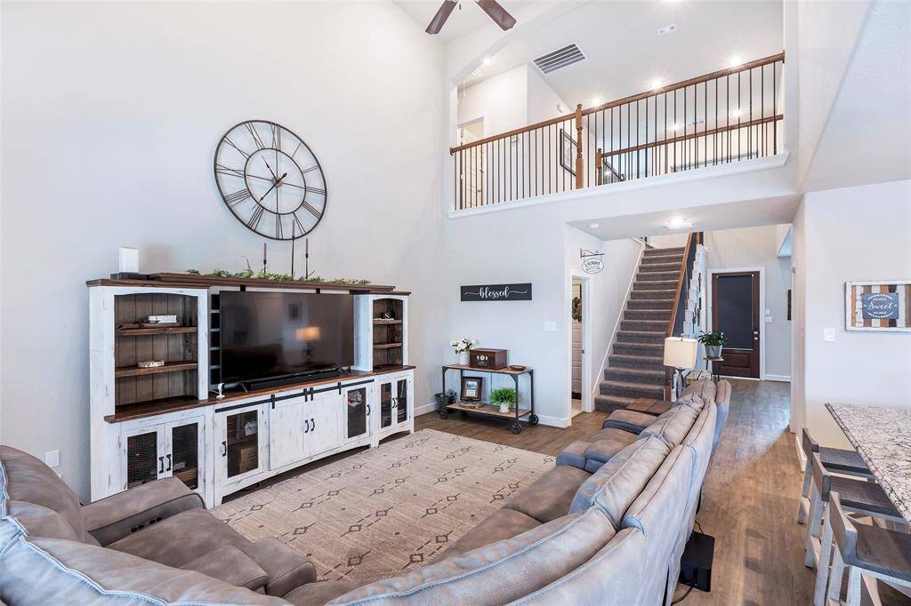 This living room features a view of the stairs leading to the second floor, with a charming balcony overlooking the space below.