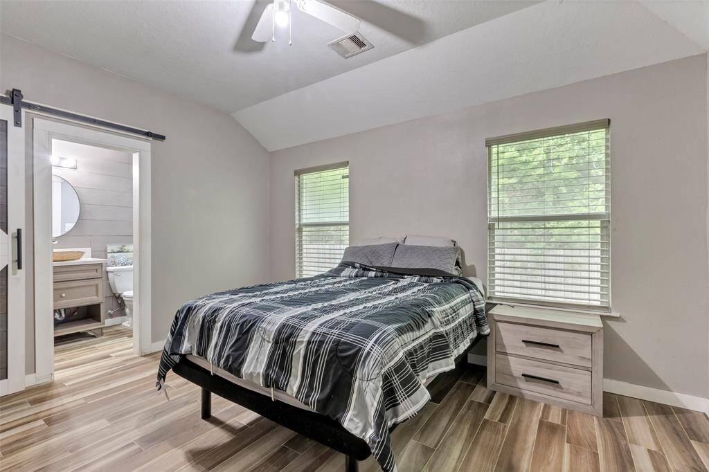 This additional view of the primary bedroom offers a glimpse into the adjoining bathroom through the open door.