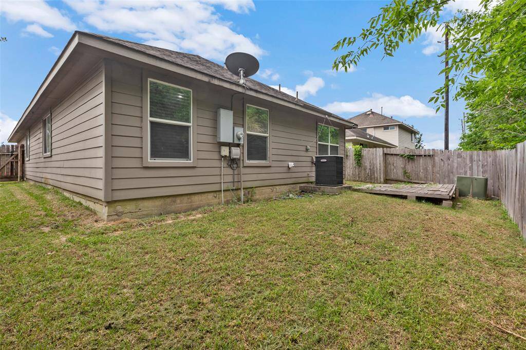 This backyard offers a private, enclosed space surrounded by a tall wooden fence, providing a secure environment for children and pets.
