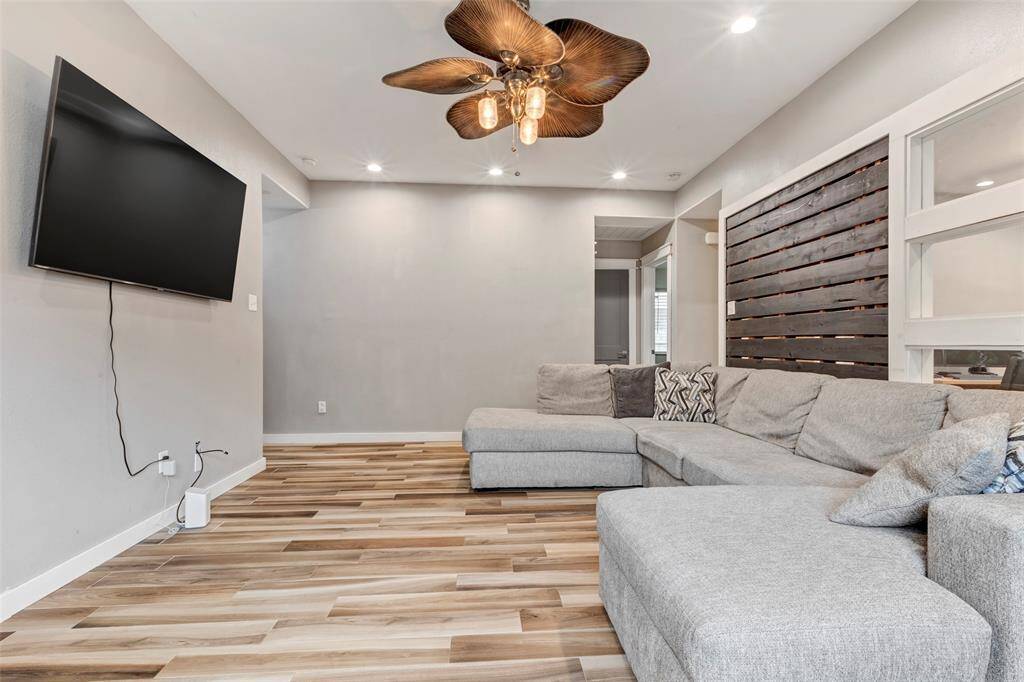 Another angle of the living room, showcasing the versatile flex room just beyond, with a view of the hallway leading to a cozy bedroom and shared bathroom.
