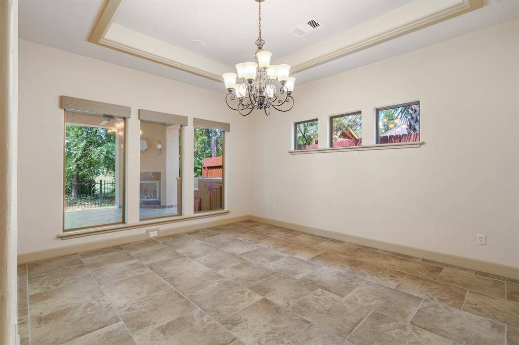 Dining room has a wall of windows overlooking the covered back patio with gas fireplace.