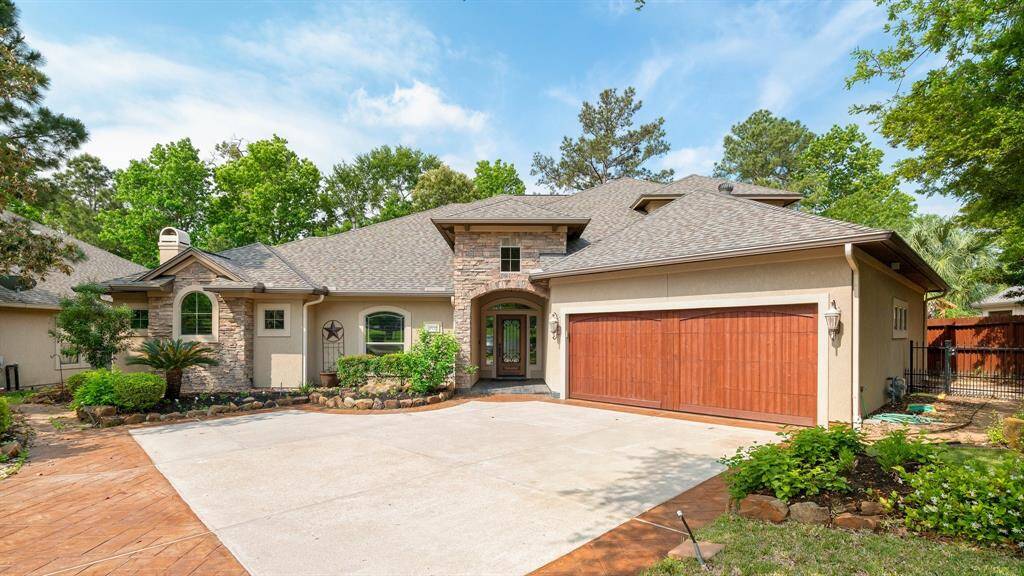 Beautiful Cannon built custom home with stone accents and solid wood garage door.