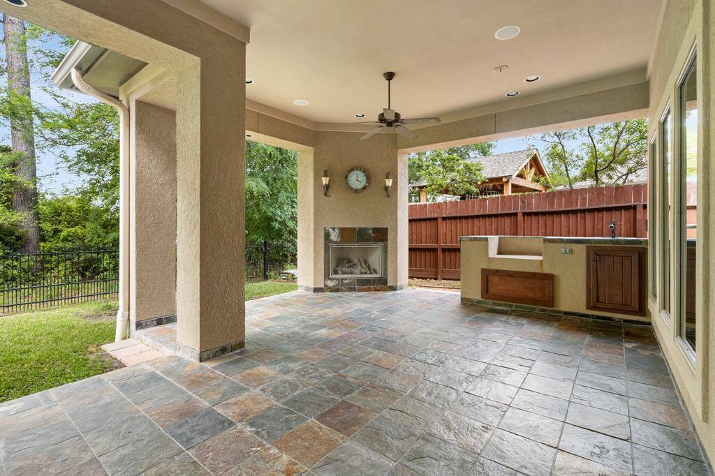 Covered patio has a great seating area with gas fireplace and outdoor area perfect for your grill and has outdoor sink.