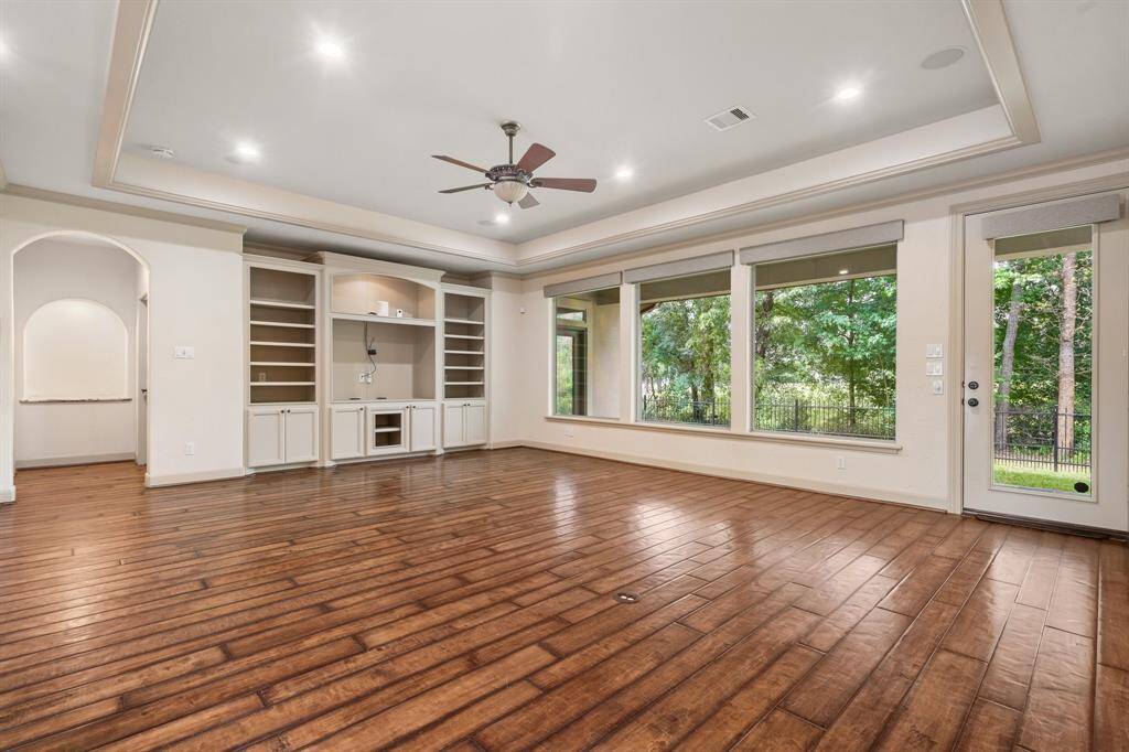 Enormous great room with wall of windows overlooking the covered patio and backyard.