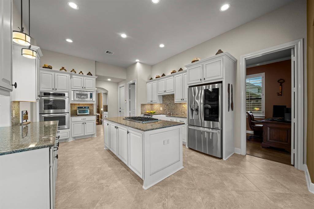 The oversized gourmet kitchen with tile floors, granite counters and custom Benedentini cabinets