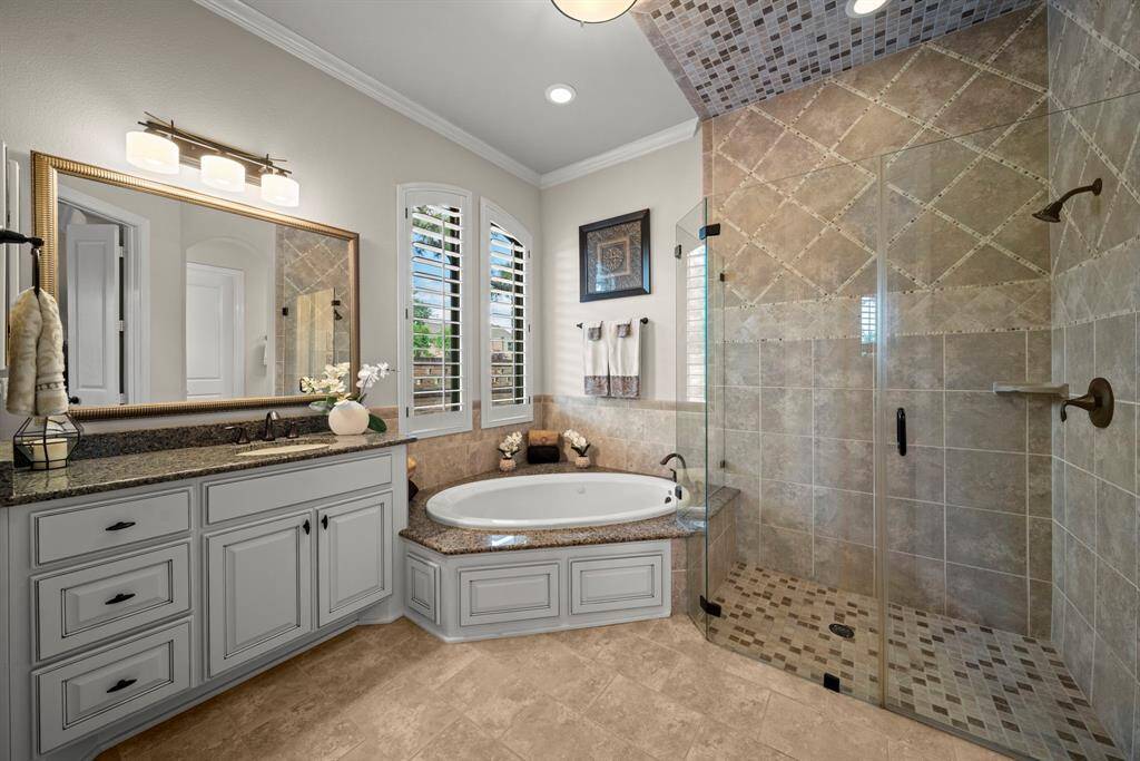 The spa like master bath with his and her vanities and generous his and her closets, custom tile work shower and jacuzzi tub