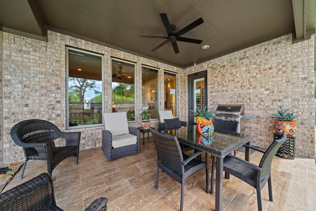 Relaxing back patio with tile floor and ceiling fan