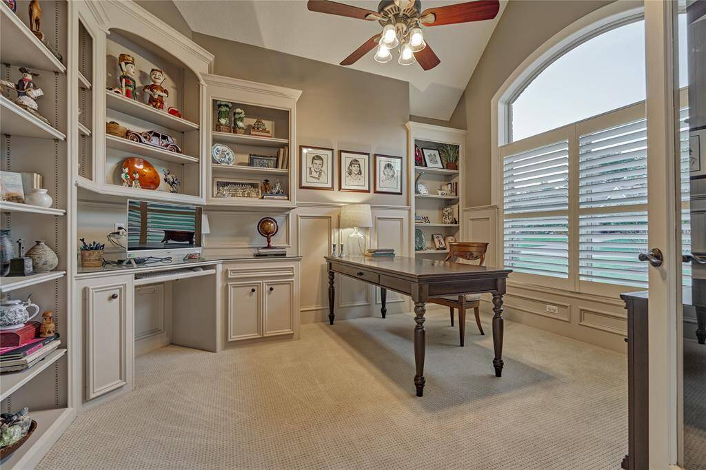 French doors lead to a handsome study with built-in cabinetry and shelving.