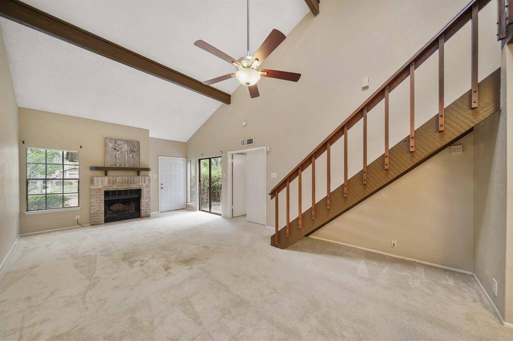 Opposite the staircase, the dining room features a high ceiling with ceiling fan & lighting, a skylight and track lighting.