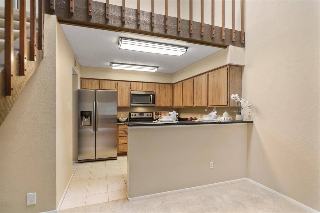 A granite surfaced breakfast bar provides a natural delineation between the kitchen & dining room and doubles as a serving counter.