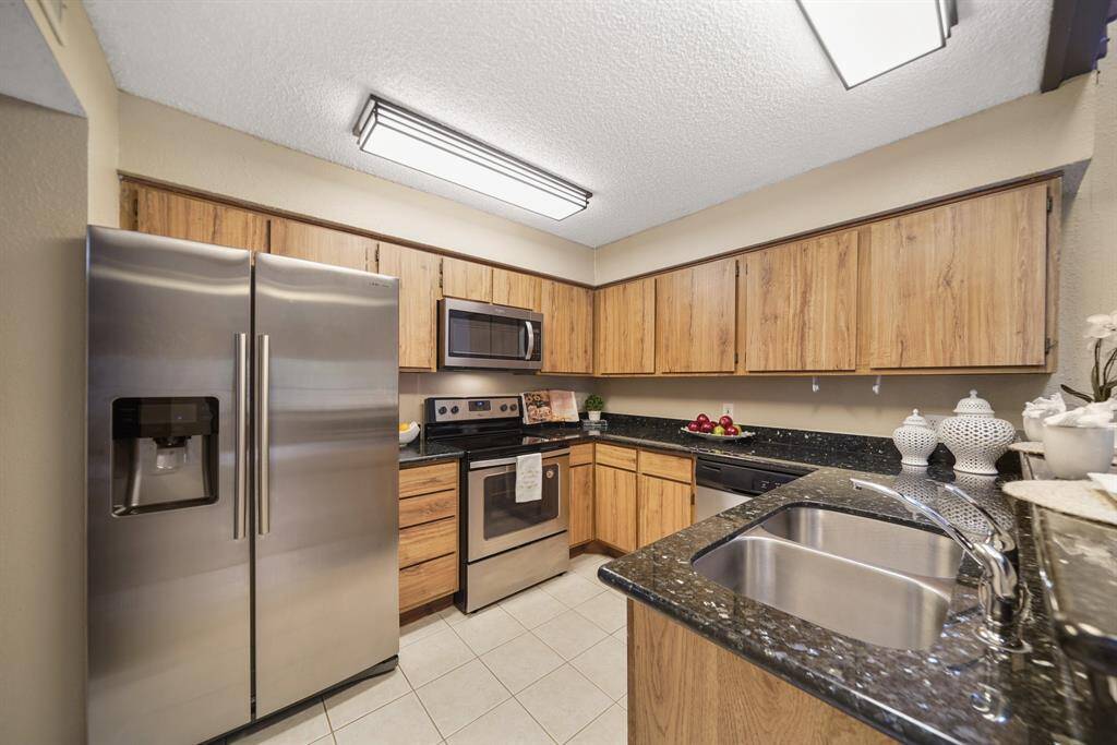 Thoughtfully planned, the kitchen includes wood-stained cabinets, upgraded granite counter tops with integrated back splashes installed in 2020 & tile flooring.