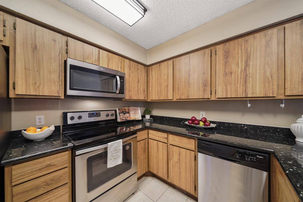 The Whirlpool stainless steel appliance package includes a 4-burner electric glass top range with conventional oven below accompanied by a built-in microwave oven with ventilation & lighting above (installed in 2020) and a dishwasher. A new 40 gallon water heater was installed in March 2025.