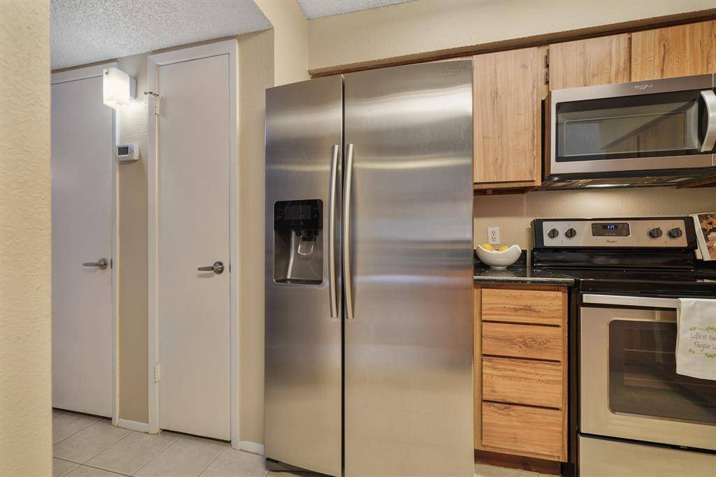 A storage pantry is included just next to the stainless steel side-by-side refrigerator/freezer with door mounted ice/water dispenser which remains with the home.