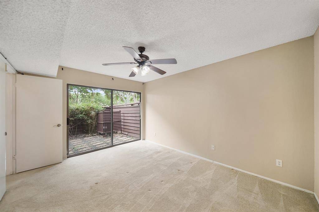 This spacious bedroom includes plenty of furniture placement opportunities, neutral paint color selections & carpet.