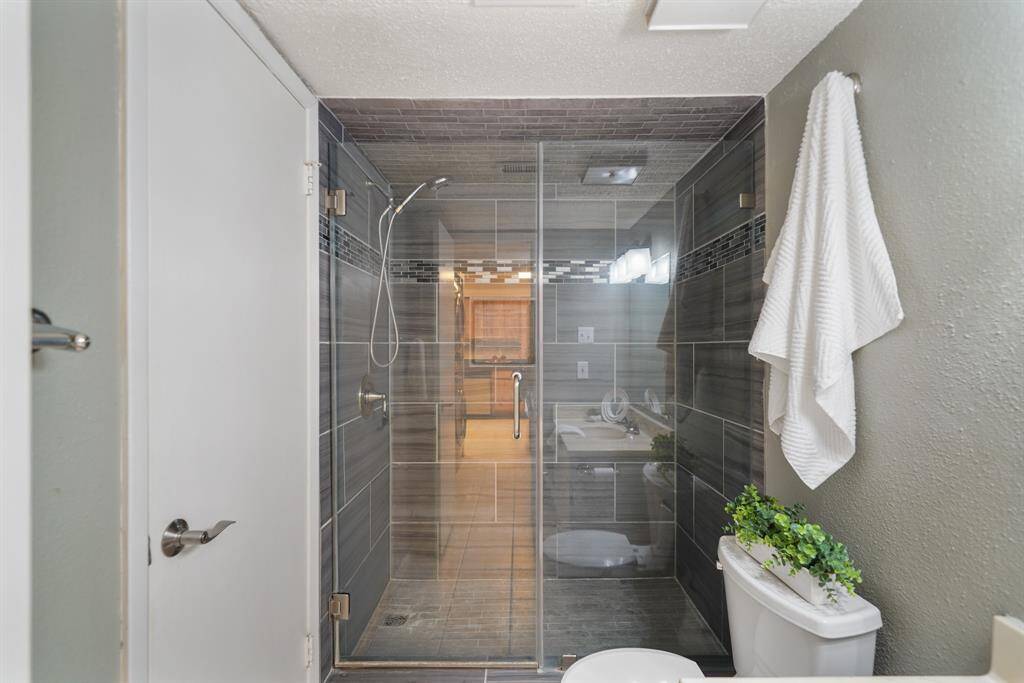 Included is an updated walk-in shower with floor-to-ceiling tiled walls, an integrated soap/shampoo shelf and frameless glass enclosure.