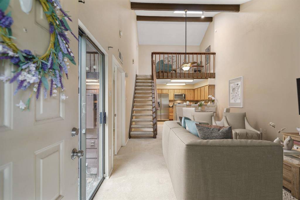 The open floor plan with first floor living spaces includes a spacious living room & formal dining area. This photo has been virtually staged.