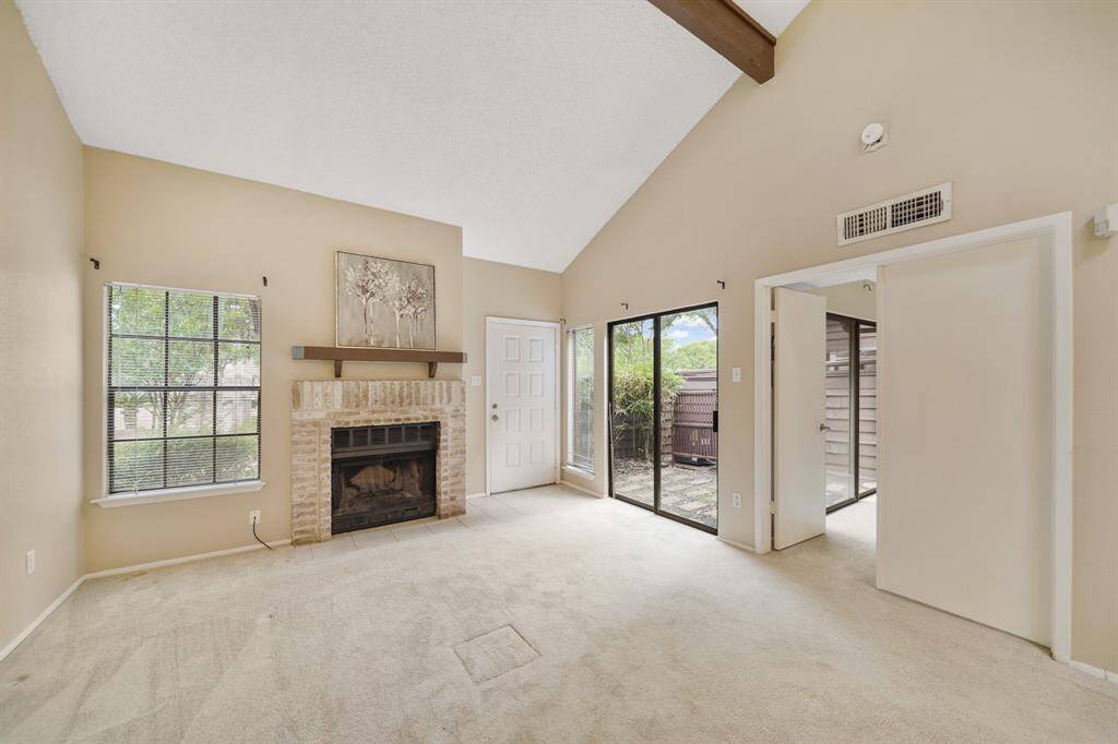 The entry way of the home with ceramic tile flooring opens to the living room and includes windows with blinds.