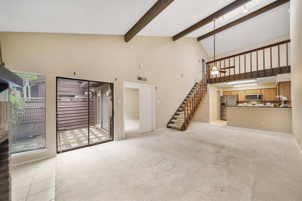 A wood-stained staircase with carpeted treads leads to the home's second floor loft. Notice all the wall space available for displaying your favorite artwork!