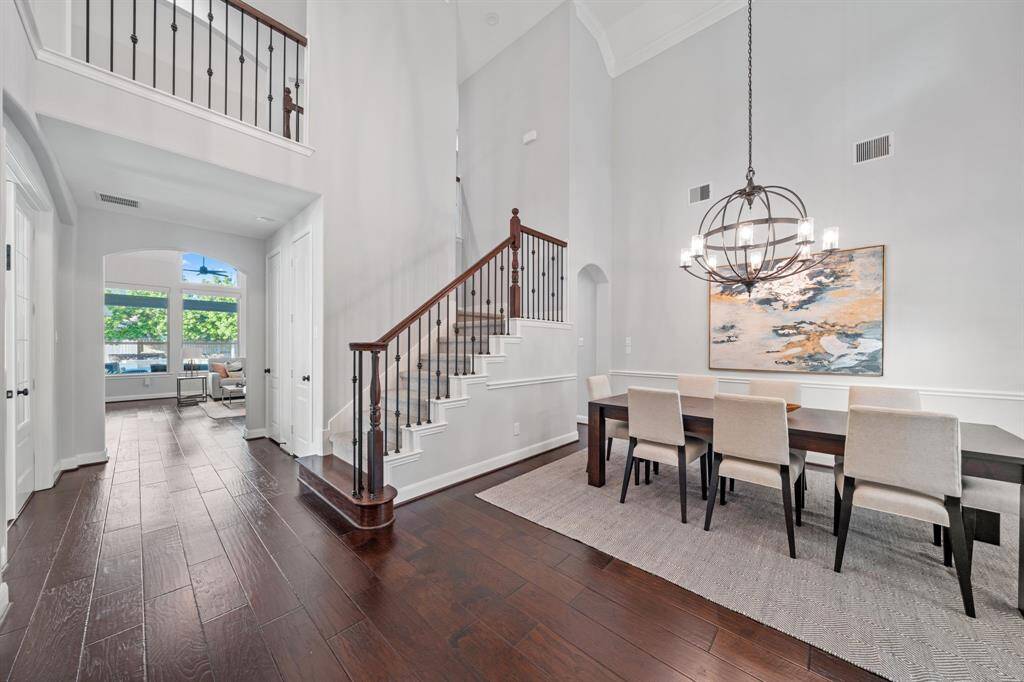An elegant dining room greets you to the right as you enter, bathed in natural light from windows overlooking the front porch, and enhanced by a sophisticated chandelier.