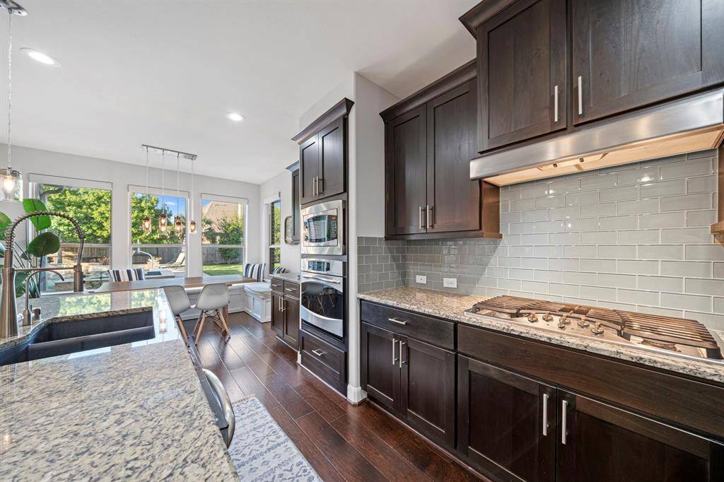 Cooking can be a luxurious experience with a built-in 5-burner gas cooktop, single oven, and ample cabinet space—all with views of the backyard oasis and a charming breakfast nook next to the windows.