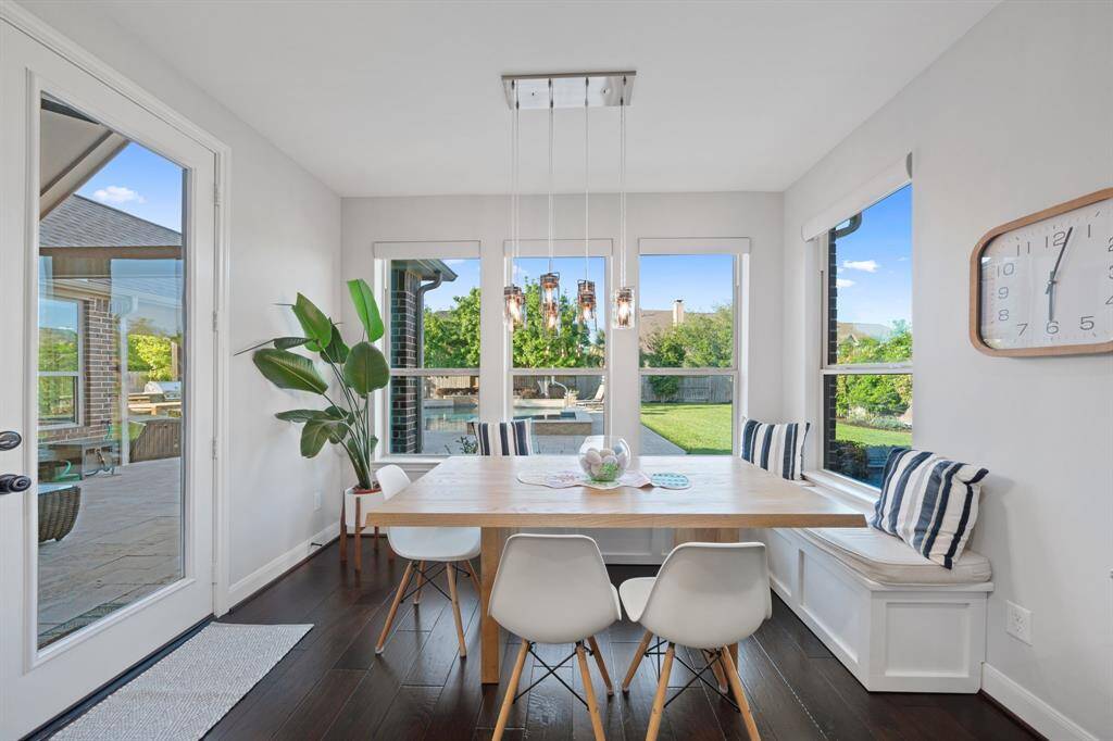 The breakfast nook is beautifully illuminated by a new chandelier complemented by stylish pendant lighting.