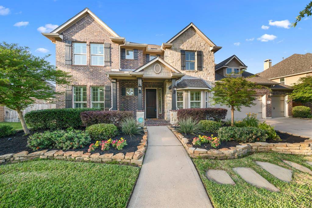 The entrance features a striking stone and brick facade complemented by a brand-new front door, creating a warm and inviting first impression.