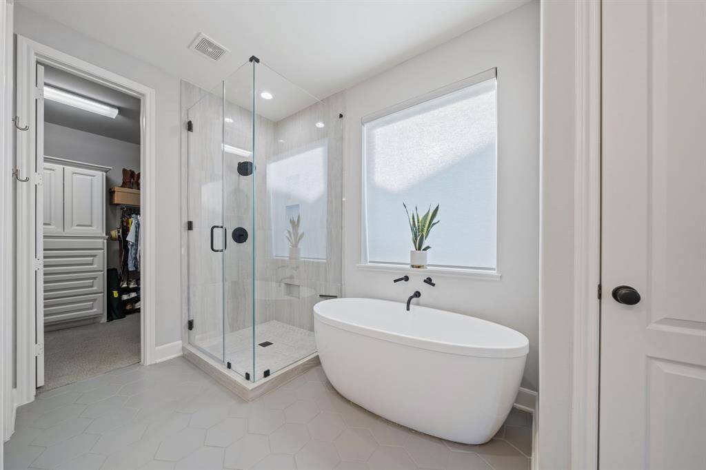 The walk-in shower boasts new tiles, complemented by plantation shutters and distinctive watermark fixtures.