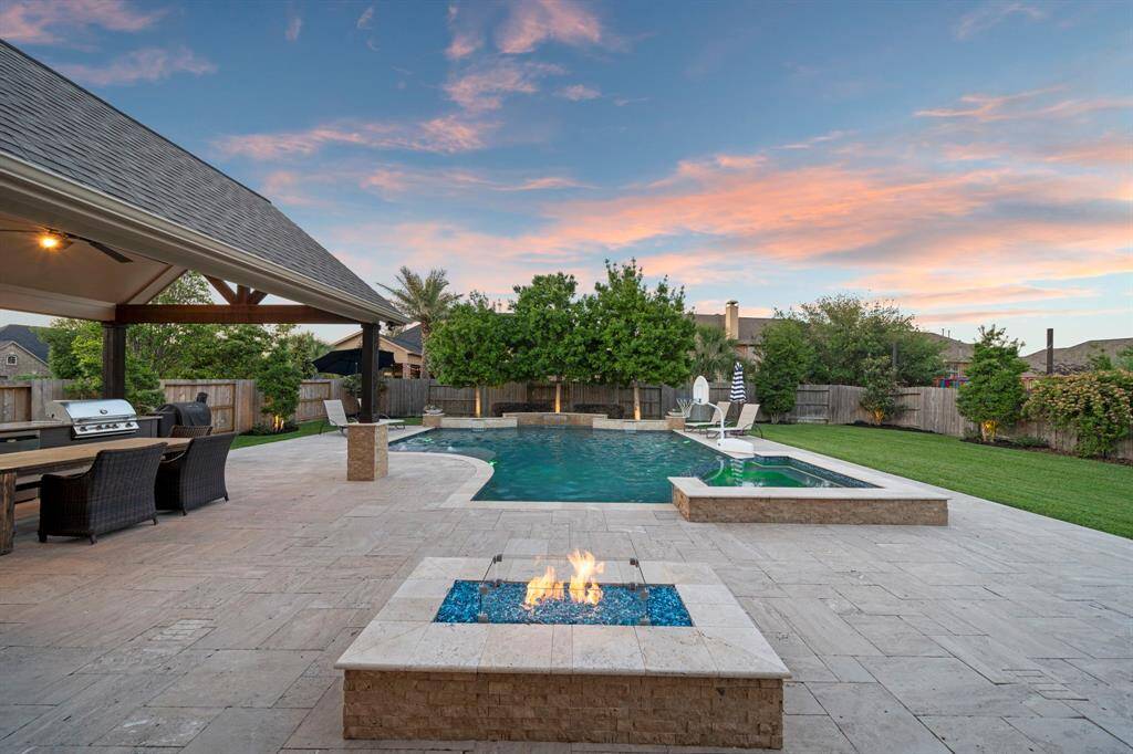 A beautiful large pool with an integrated hot tub/water features.