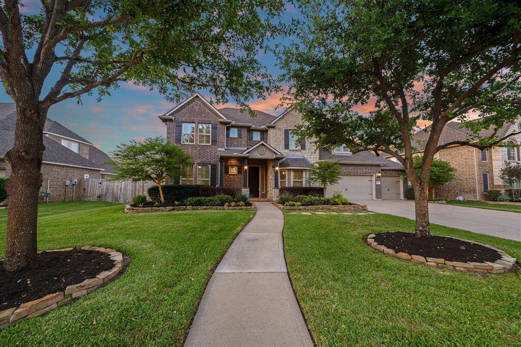 The front yard is beautifully illuminated with carefully placed landscape lighting.