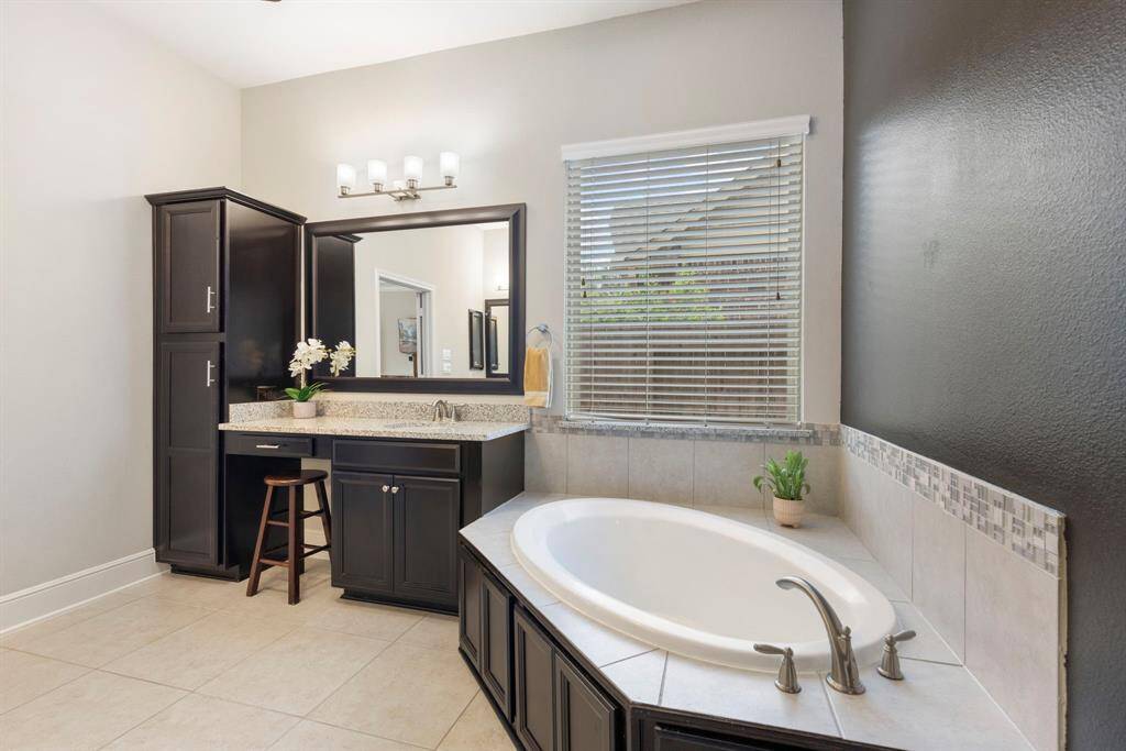 With granite counters, framed mirror, large soaker tub, walk-in shower and generous storage, the primary bath boasts all the expected amenities.