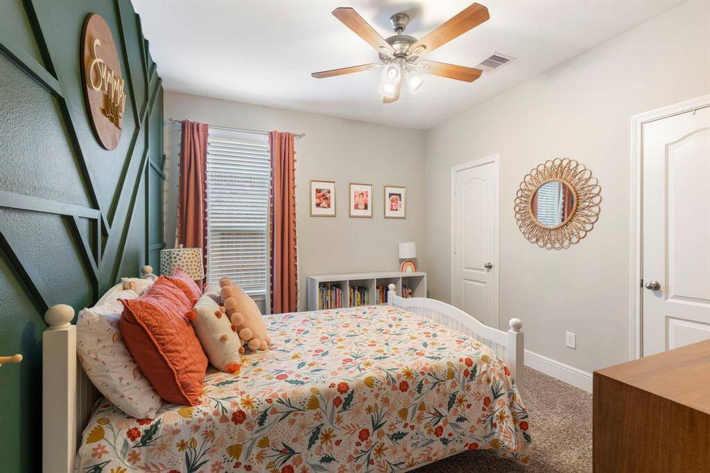 Secondary bedroom highlights a custom designed wood accent wall and spacious closet.