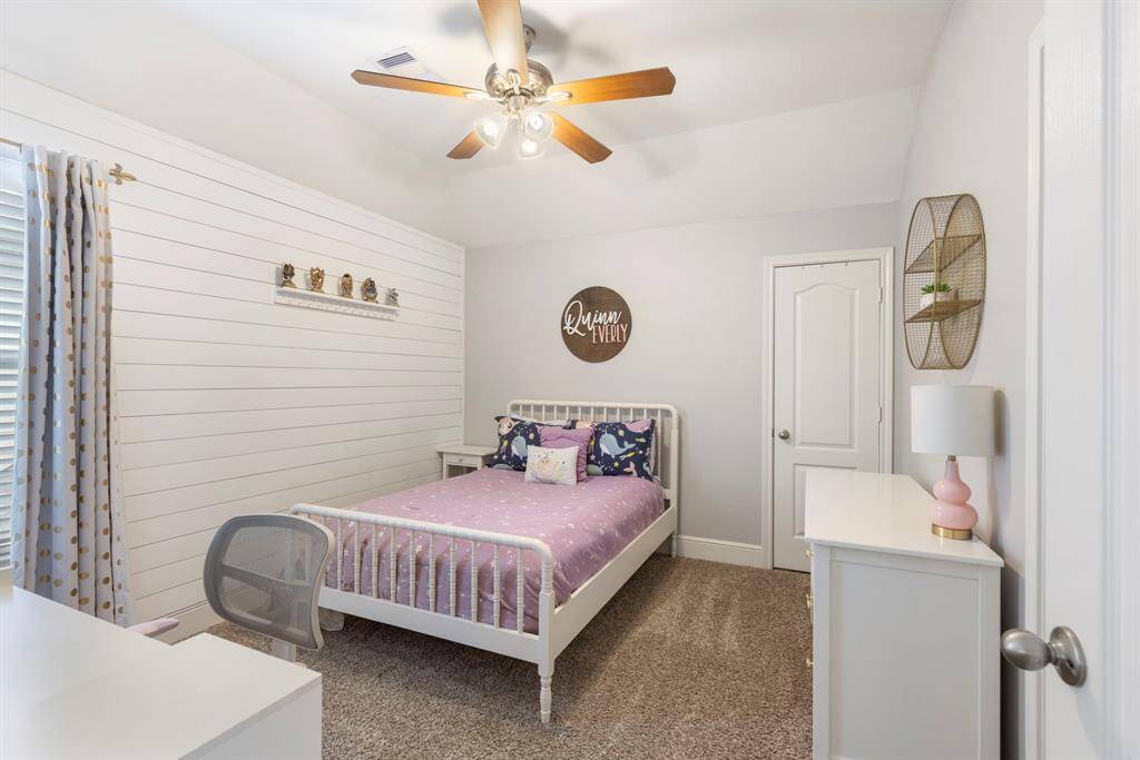A decorative wainscotting wall provides a touch of flair to this secondary bedroom.