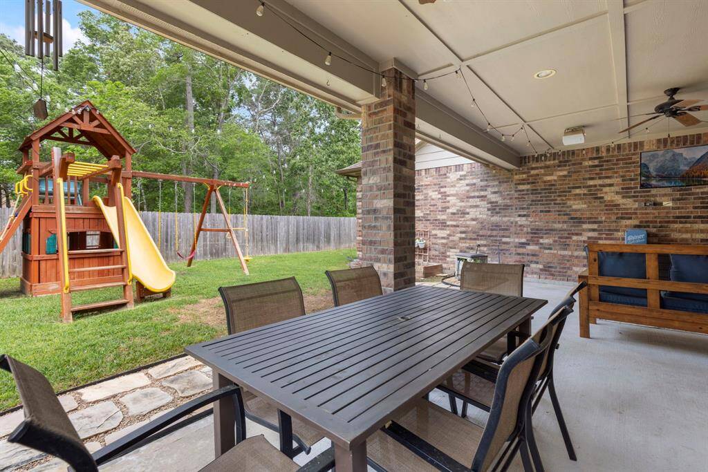 The covered patio offers plenty of space for outdoor dining and includes a cozy area perfect for relaxing and watching TV al fresco.