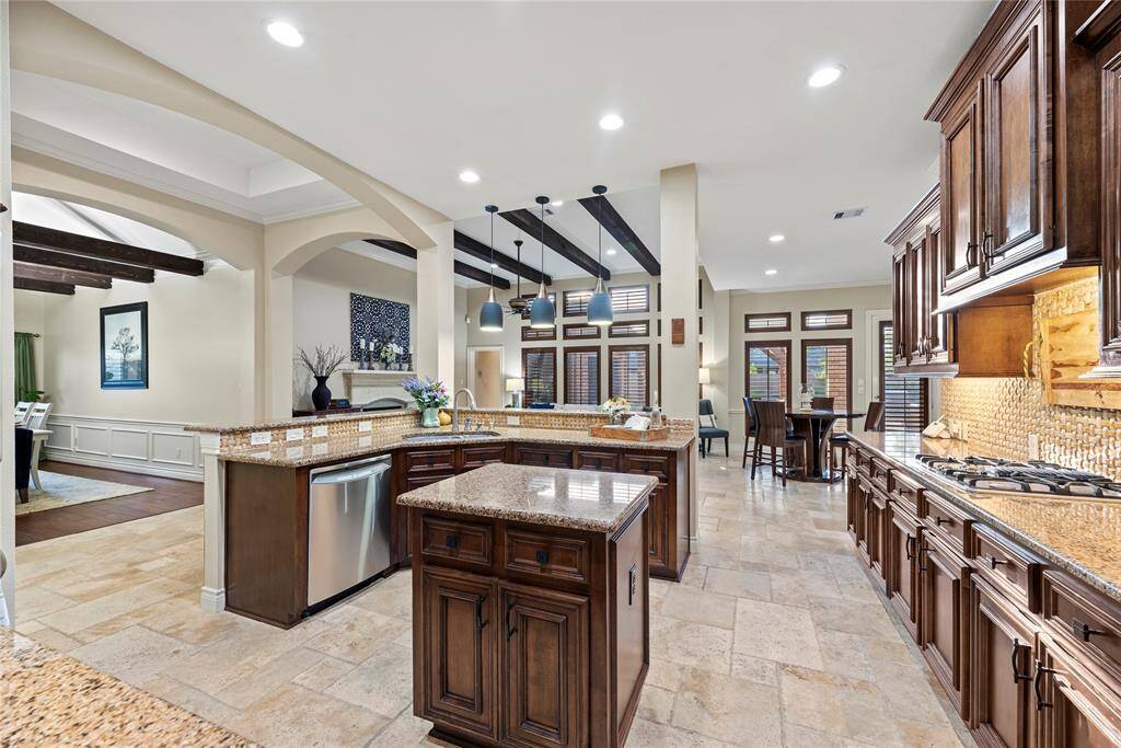 Your chef inspired kitchen awaits! Features include granite countertops paired with a coordinating tile backsplash, stainless steel appliances, rich cabinets with updated hardware, under cabinet lighting, recessed lighting, and a center island.