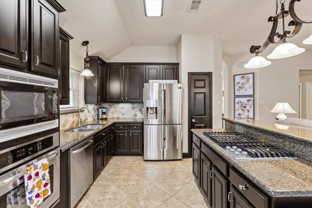 The open-concept kitchen boasts sleek stainless steel appliances and features a well-thought-out workflow, making cooking and meal preparation a breeze. This modern design not only enhances functionality but also creates an inviting atmosphere for entertaining and family gatherings.