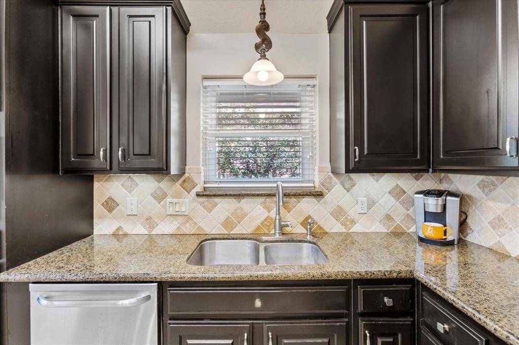 The designer backsplash complements the rimless sink and dark cabinetry beautifully, creating a sophisticated and cohesive look in the kitchen. This stylish combination not only enhances the aesthetic appeal but also adds a touch of elegance to the space.