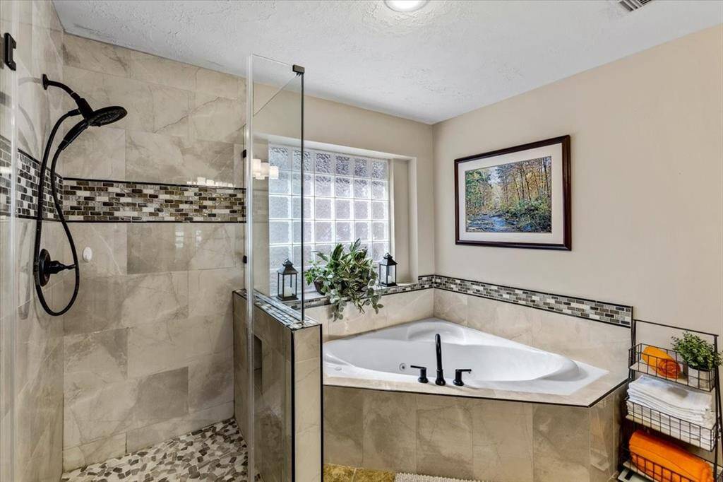 Discover your tranquil retreat in this sleek ensuite, boasting a deep soaking tub, an expansive walk-in shower, and dual vanities - all designed for supreme comfort and style.