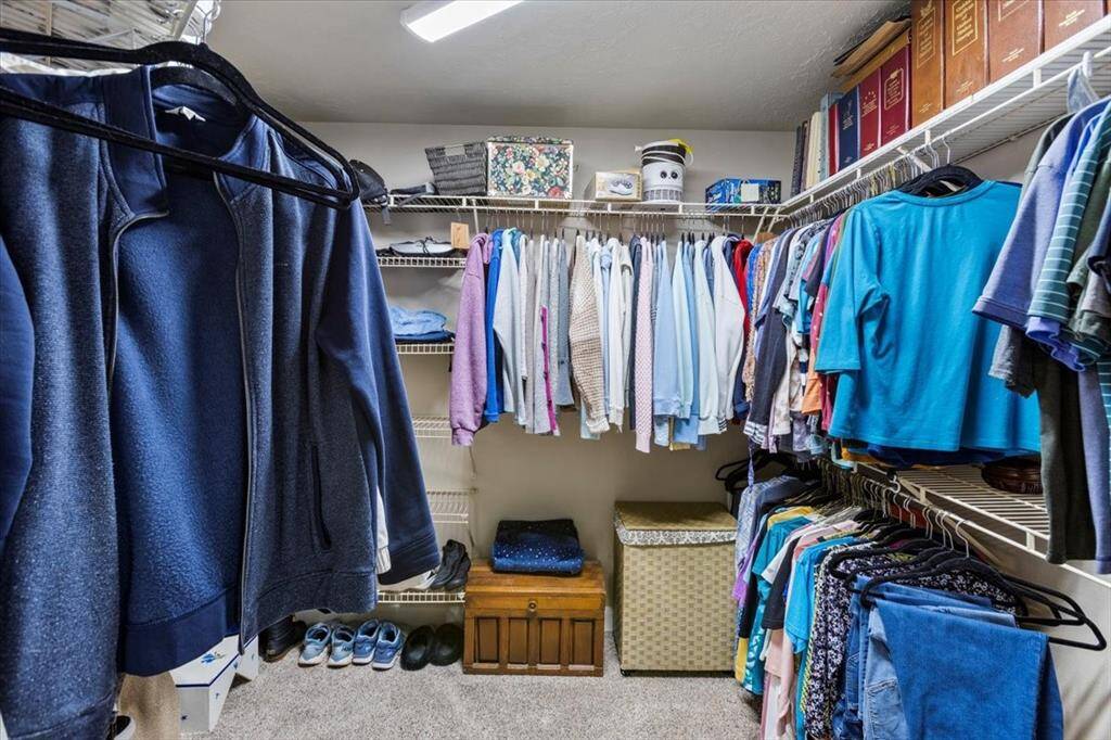 Enjoy the comfort and luxury of plush carpeting in this generous walk-in closet, perfect for organizing your wardrobe essentials with ease.