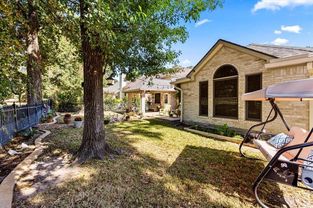 Enjoy the shaded backyard, perfect for outdoor relaxation, with a secure wrought iron fence that keeps pets and little ones safely within the yard while still offering an open, scenic view