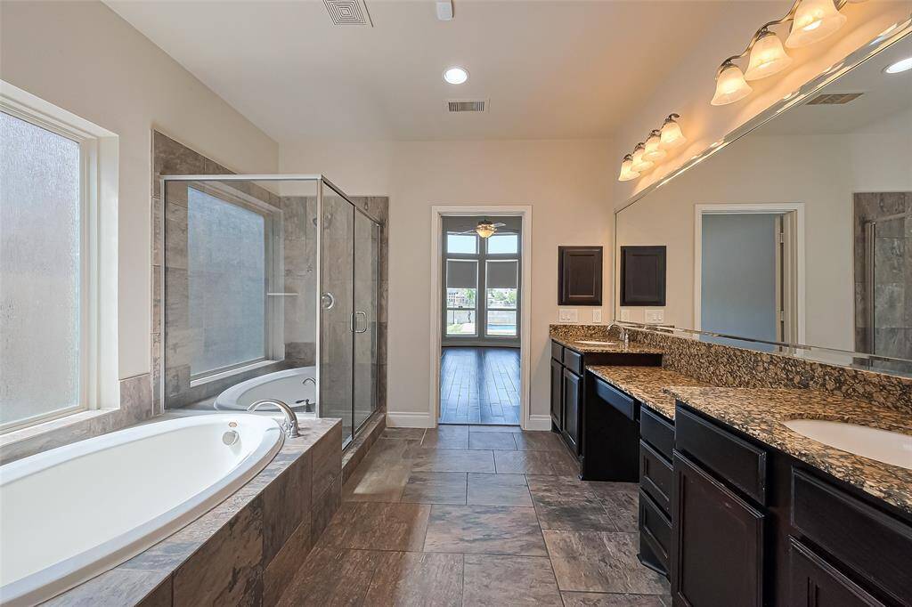 The spacious primary bathroom with a double vanity, separate shower, and soaking tub.