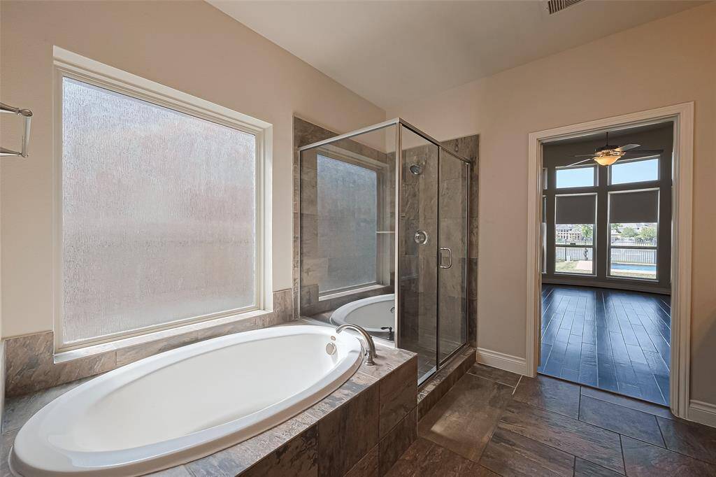 The spacious primary bathroom with a double vanity, separate shower, and soaking tub.