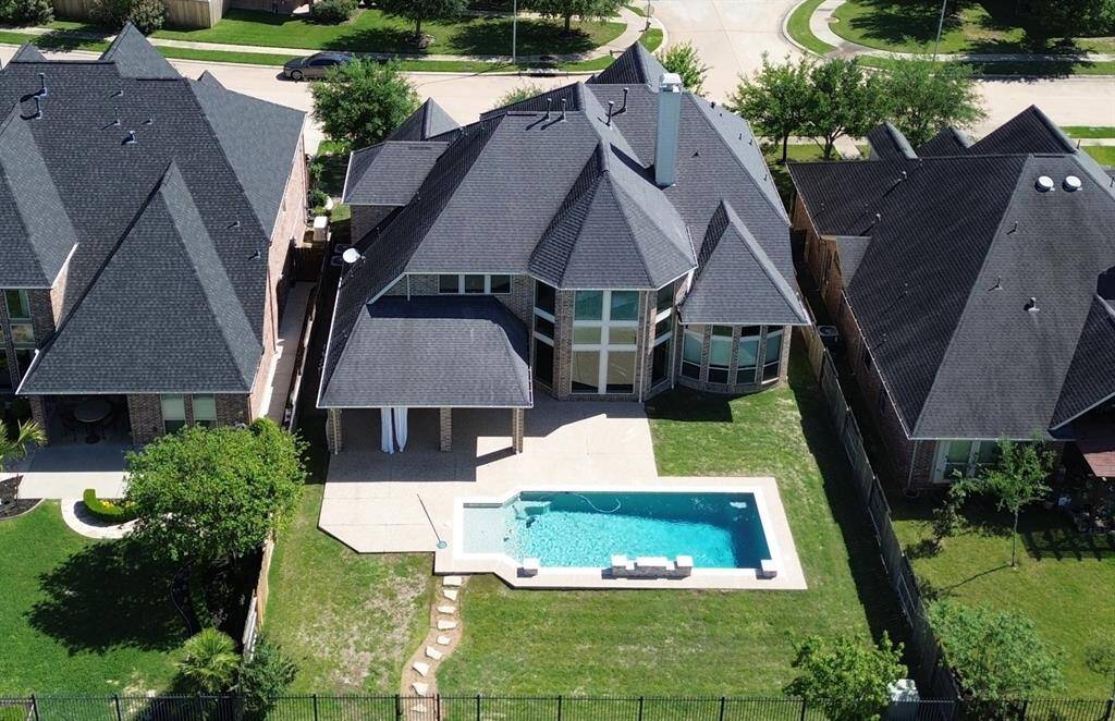 The backyard oasis features an oversized pool with sundeck, large covered patio, direct access through the gate to the lake, and plenty of yard left for the kids and pets to play!