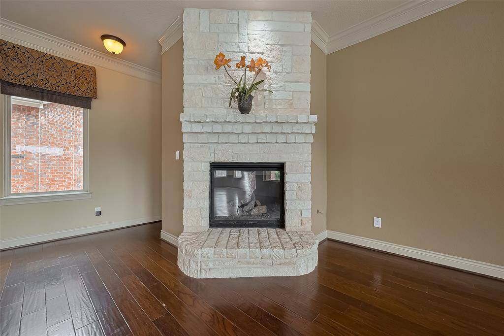 Gaslog Fireplace highlights the Den with easy to maintain wood floors.