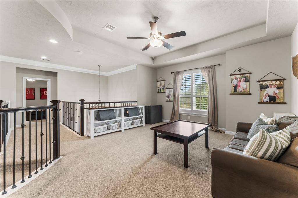This photo showcases the gameroom at the top of the stairs. The space features a railing overlooking the lower level.